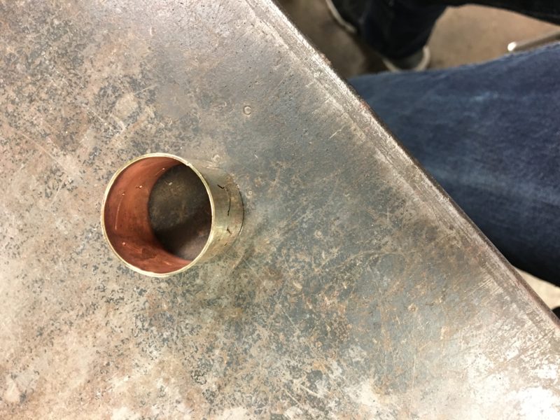 My chain link sitting on a table, view partially from above. You can see one shiny gold outside part and one matte pink inside part.