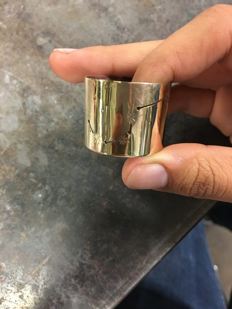 Me holding my chain link so that you can see the shiny golden side and the Big Dipper constellation.