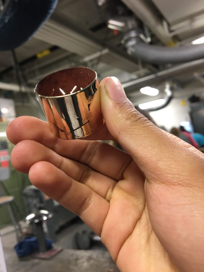 Me holding my chain link up to the light so that light shines through the constellation lines.