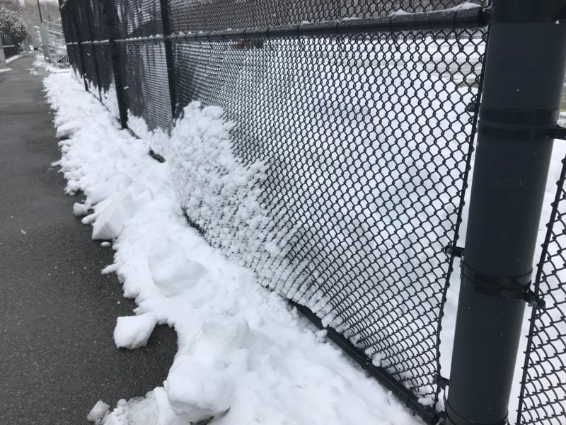snow bulging through a fence