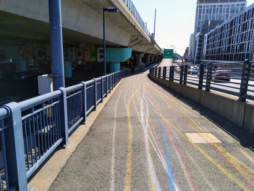 colorful lines appear on the sidewalk, as if drawn with chalk. they stretch to the horizon.