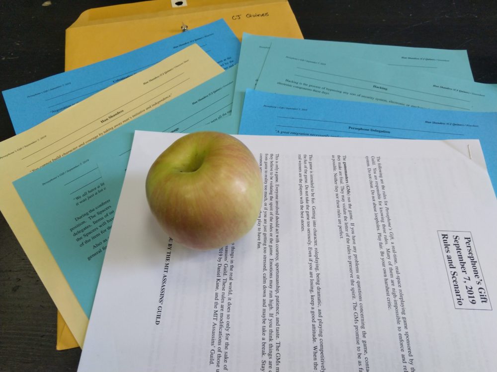 an apple lying on a stack of papers, and underneath is a folder