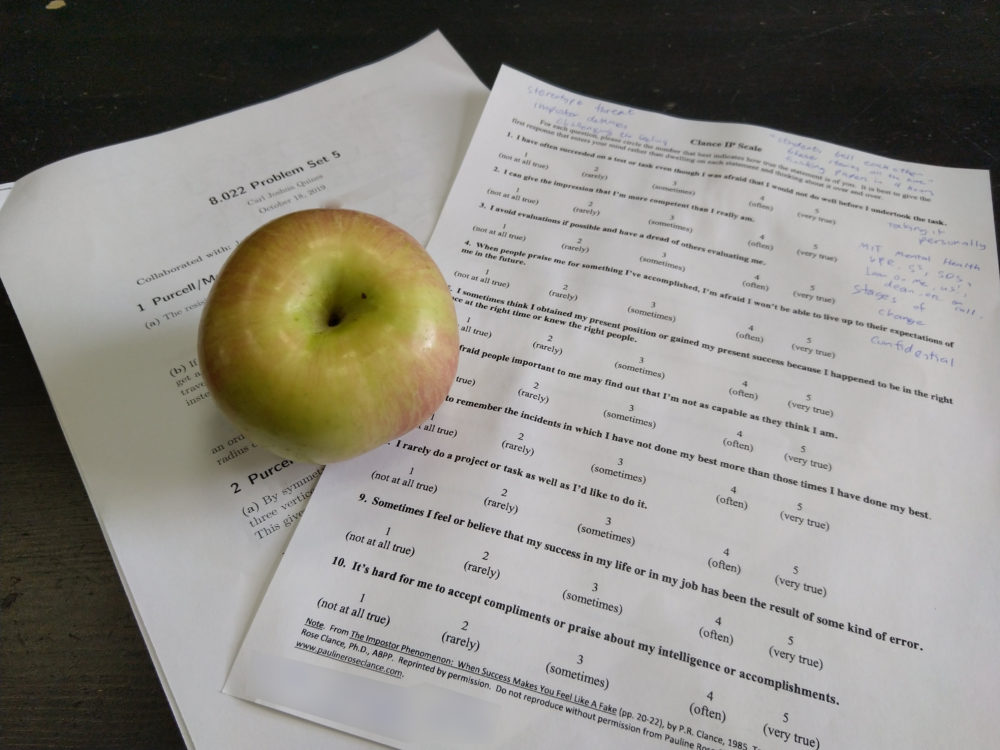 an apple lying on top of two sheets of paper.