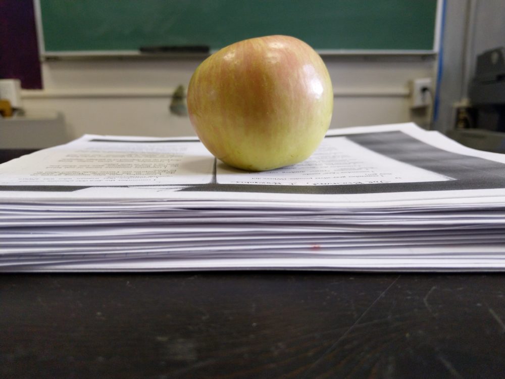 an apple on a stack of paper.