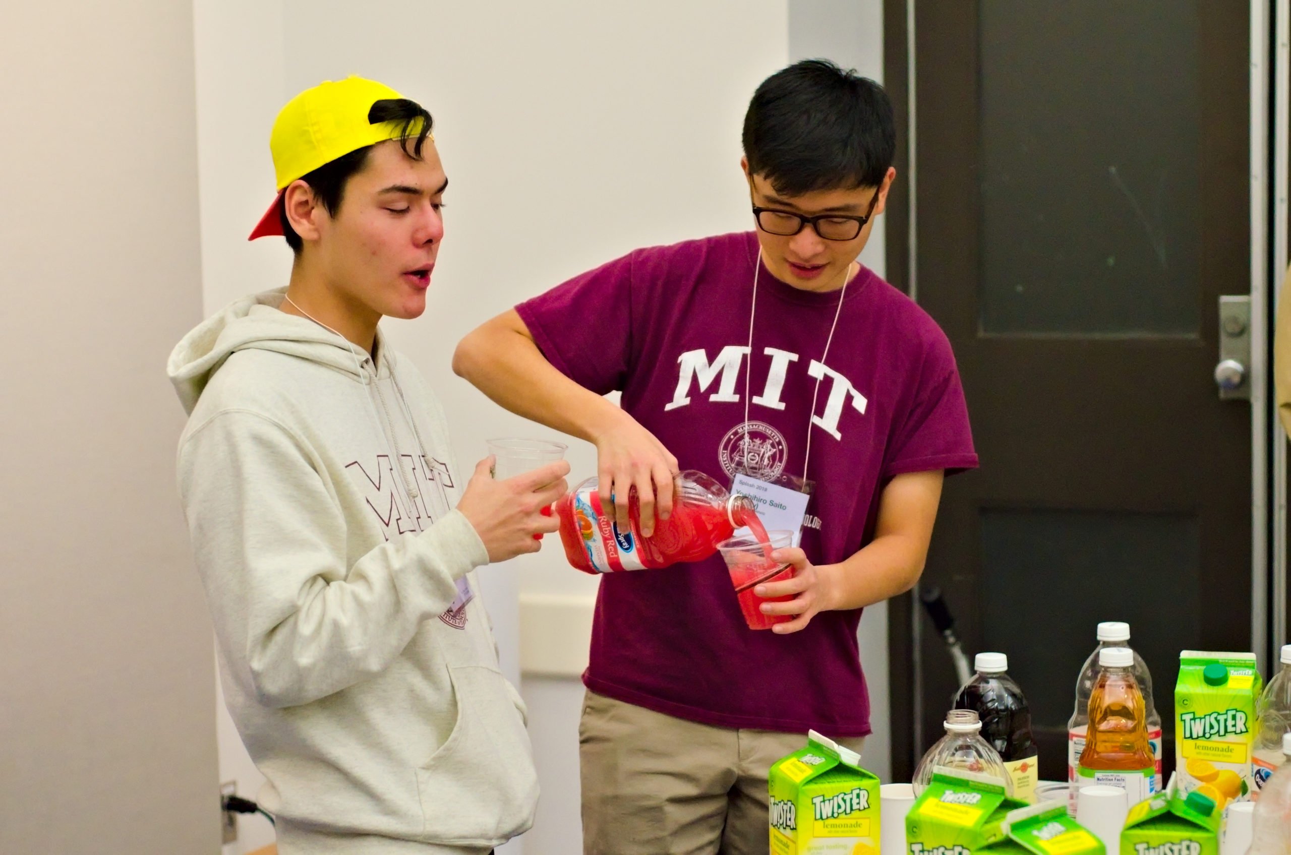 yoshi s. ’22 pours ruby red into a cup; marco n. ’23 stands next to him with a full cup