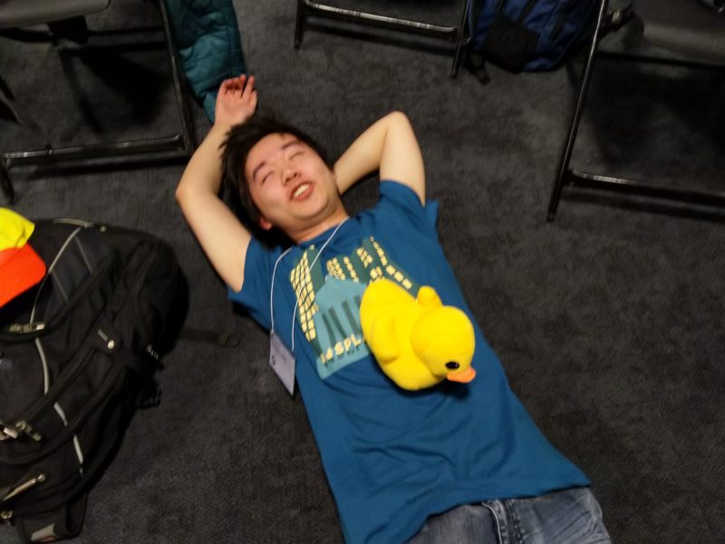 jeffery lying down on the floor with a duck on him