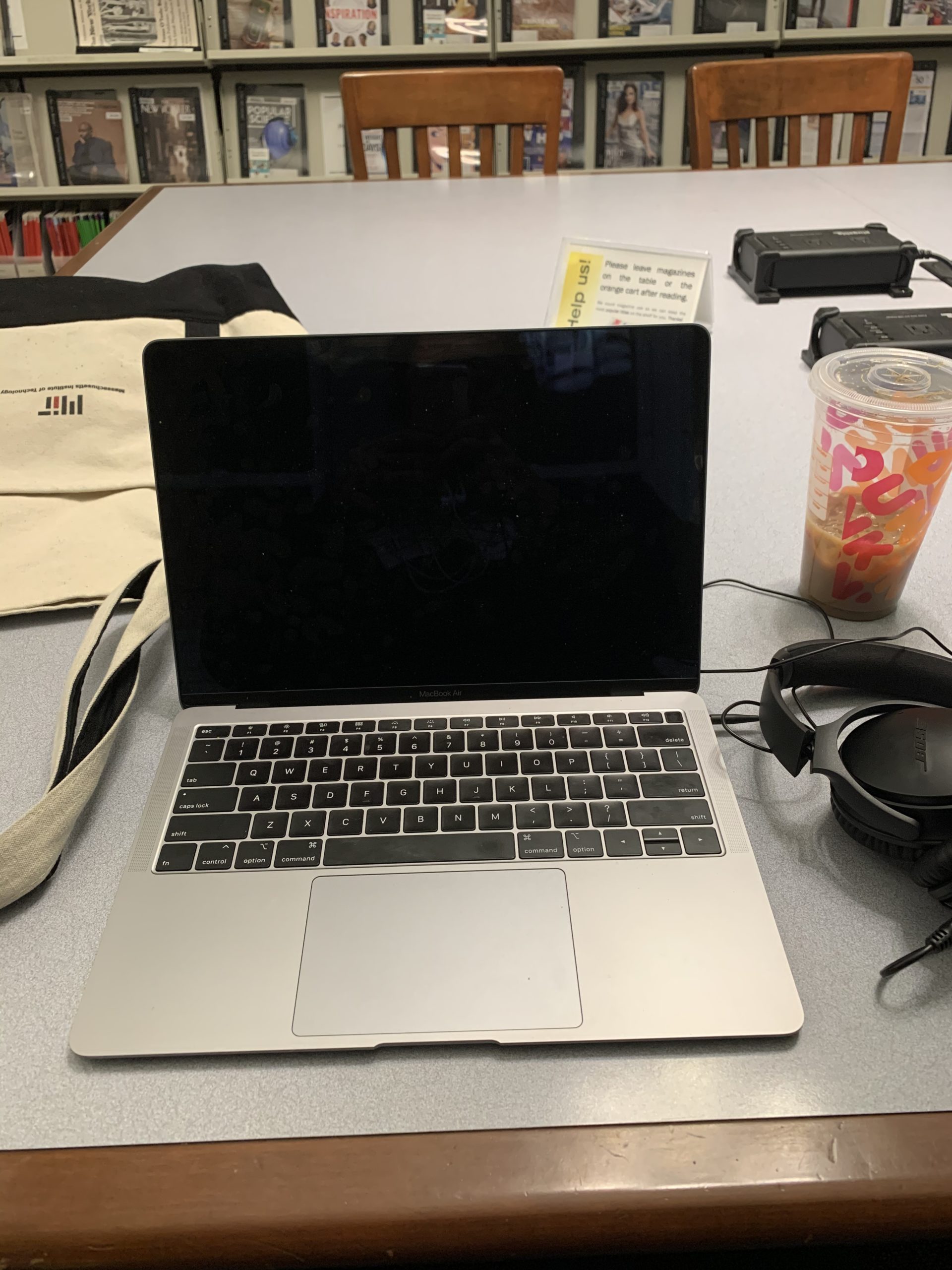 Tiffany's laptop and Dunkin' Doughnuts cup at a library table