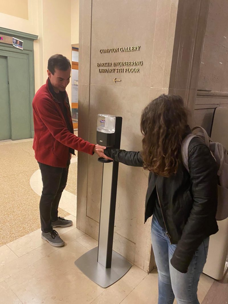 shaking hands at a purell dispenser