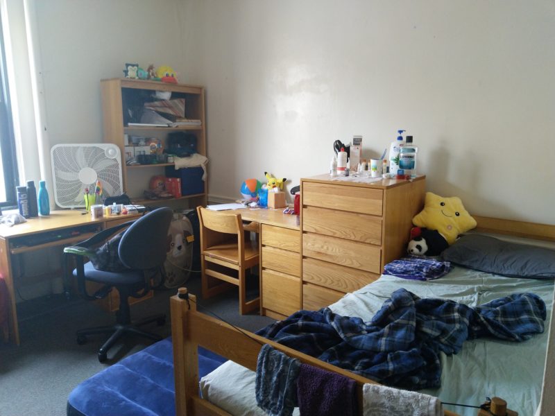 a bed, a stuffed star, a cabinet, a desk, an air mattress on the floor. lots of stuff