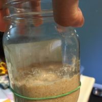 My sourdough starter in a mason jar. It's grown above the rubber band indicating its…