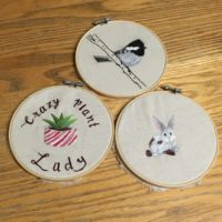 3 embroidery hoops with a bird, plant, and rabbit embroidered