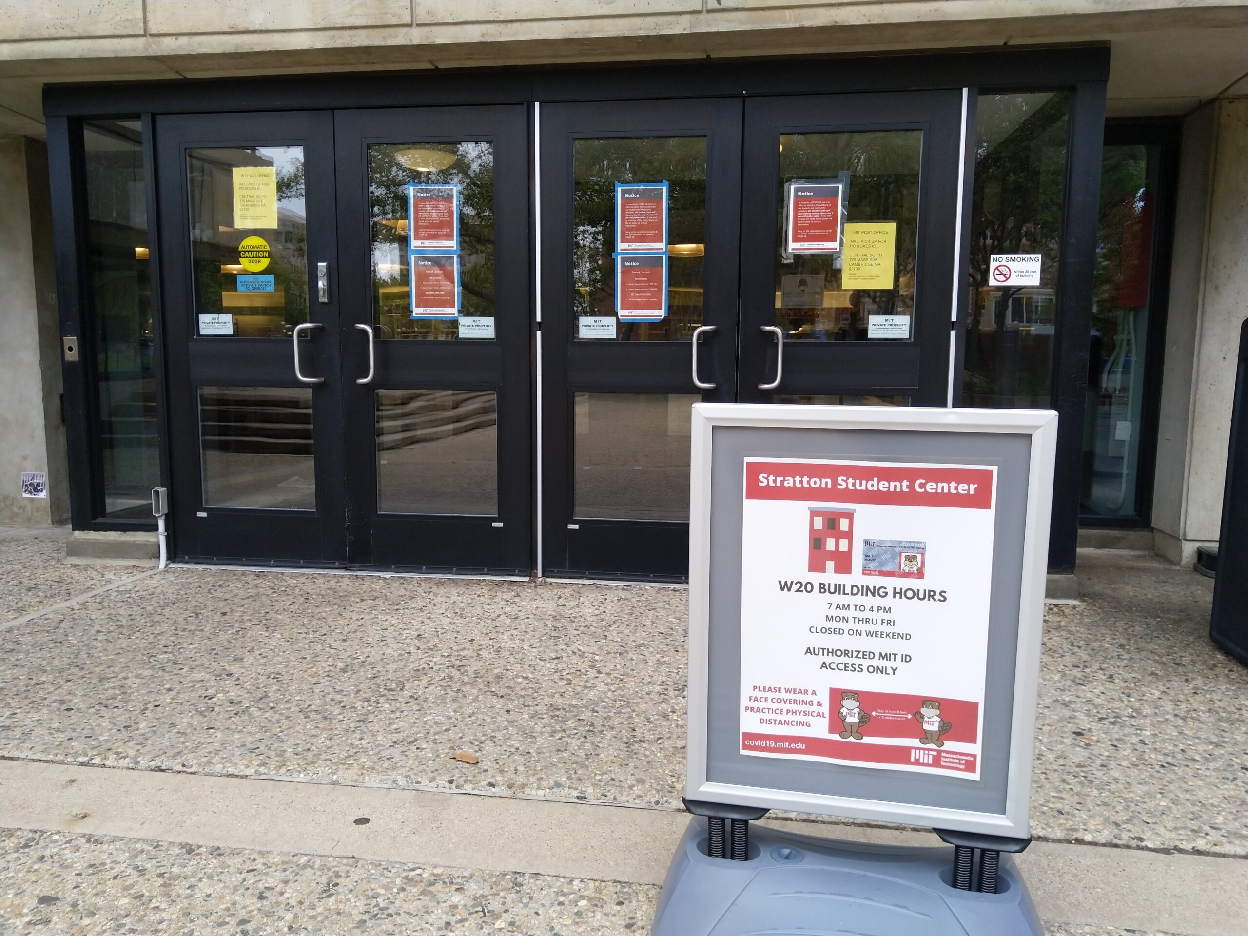 the doors of the student center with red sheets of paper taped to the doors. a sign in front has text including "AUTHORIZED MIT ID ACCESS ONLY"