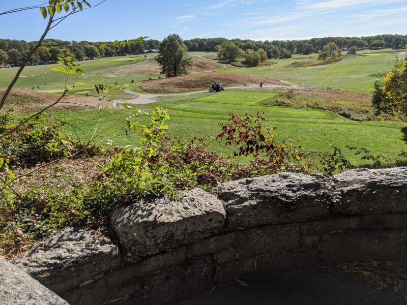 view of a golf course from a hill