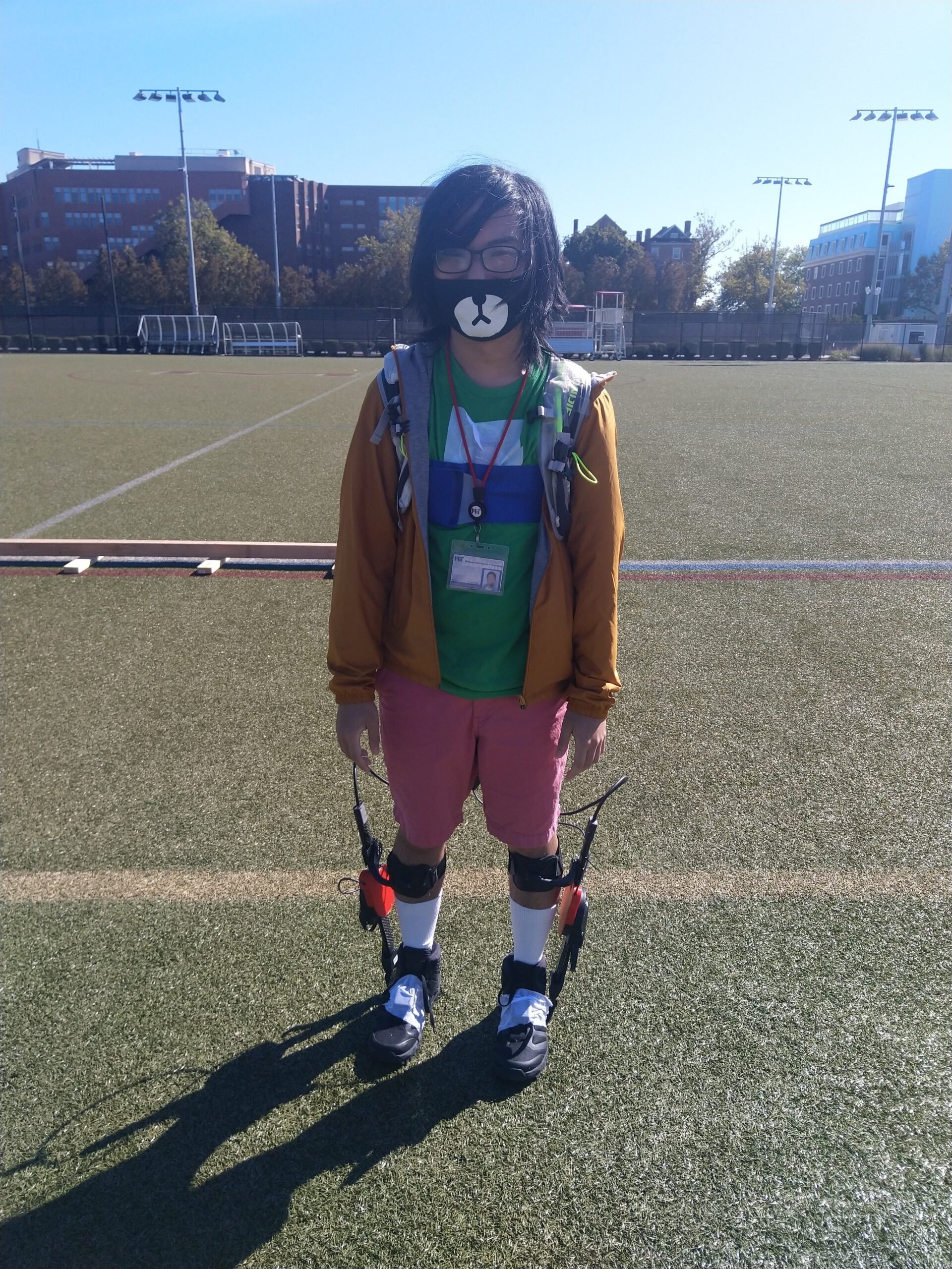 me wearing the exoskeleton! it looks like some plastic attached to the sides of my shoes to around the bottom of my knees