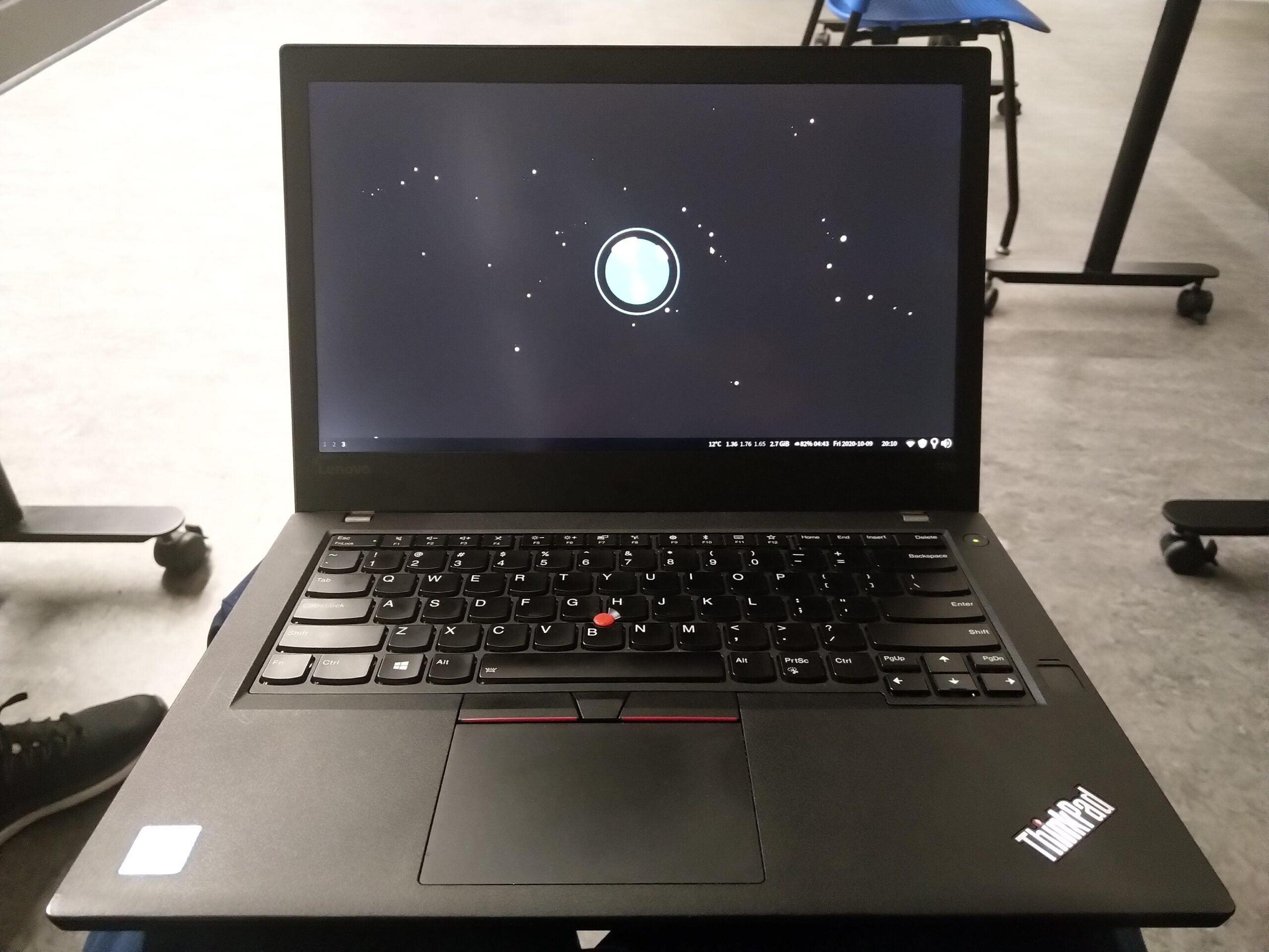 a laptop. the desktop has a wallpaper with a drawing of the earth and some stars.