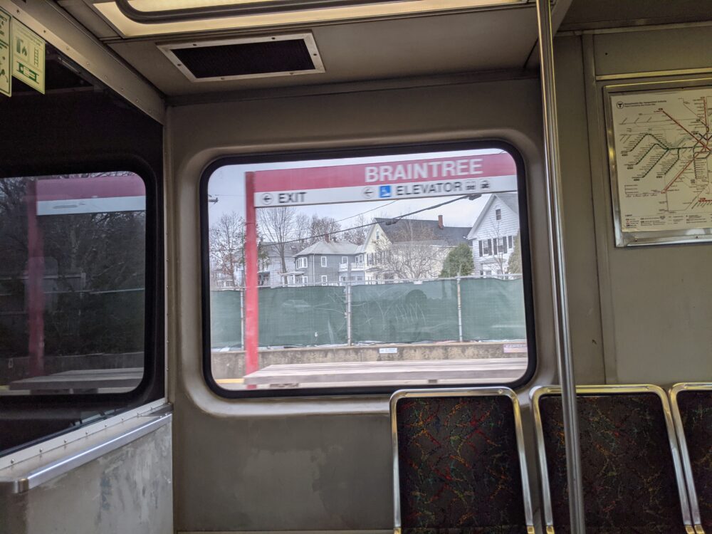 blurry picture of the Braintree station sign from inside a train