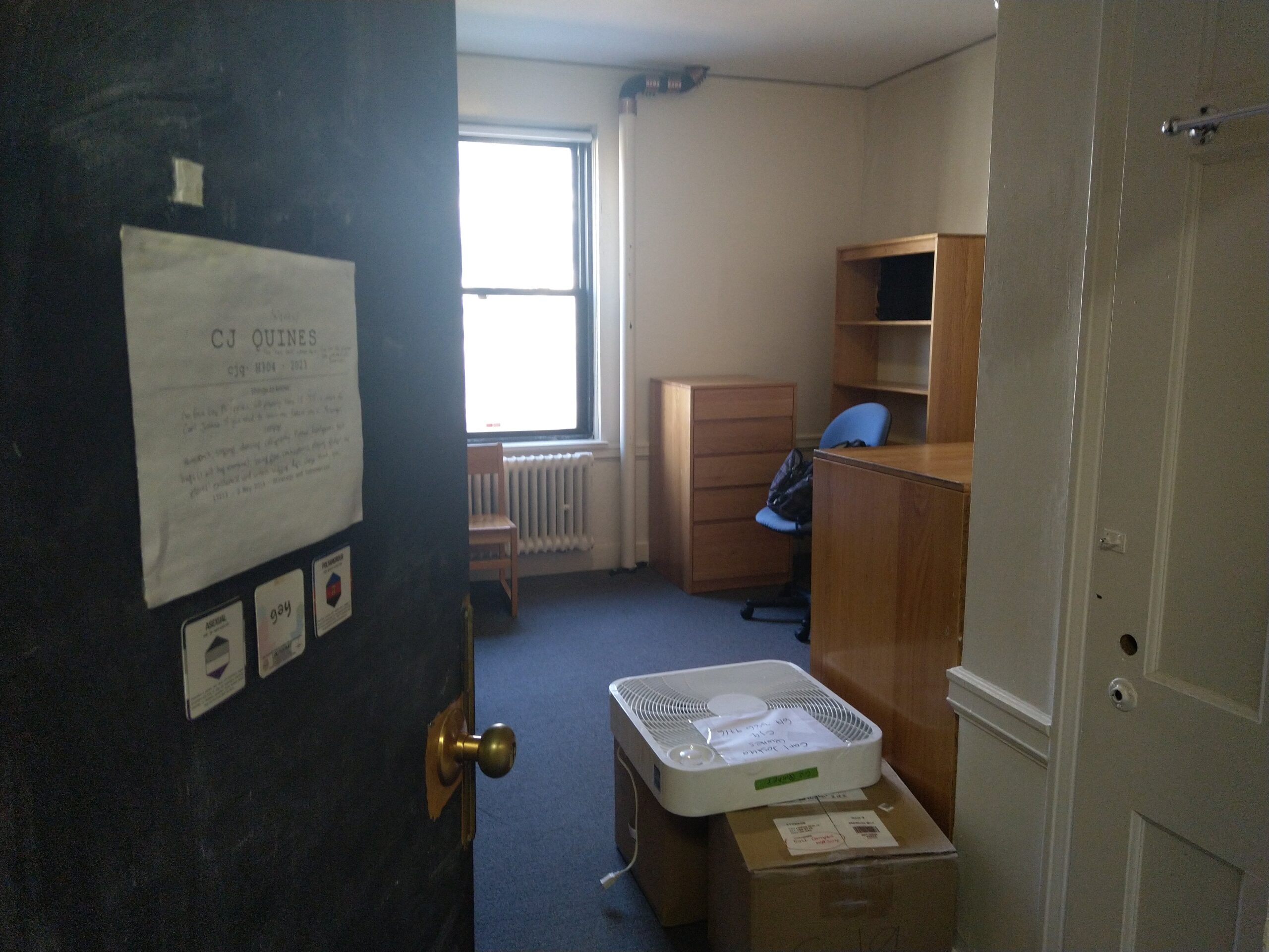 my room in east campus, empty, with two boxes on the floor