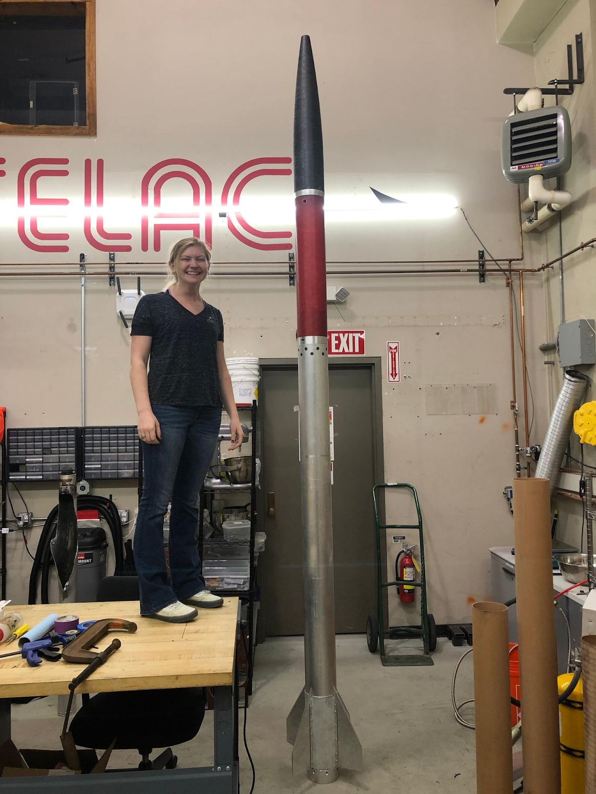 Rocket Team member standing on a table next to our single-stage rocket