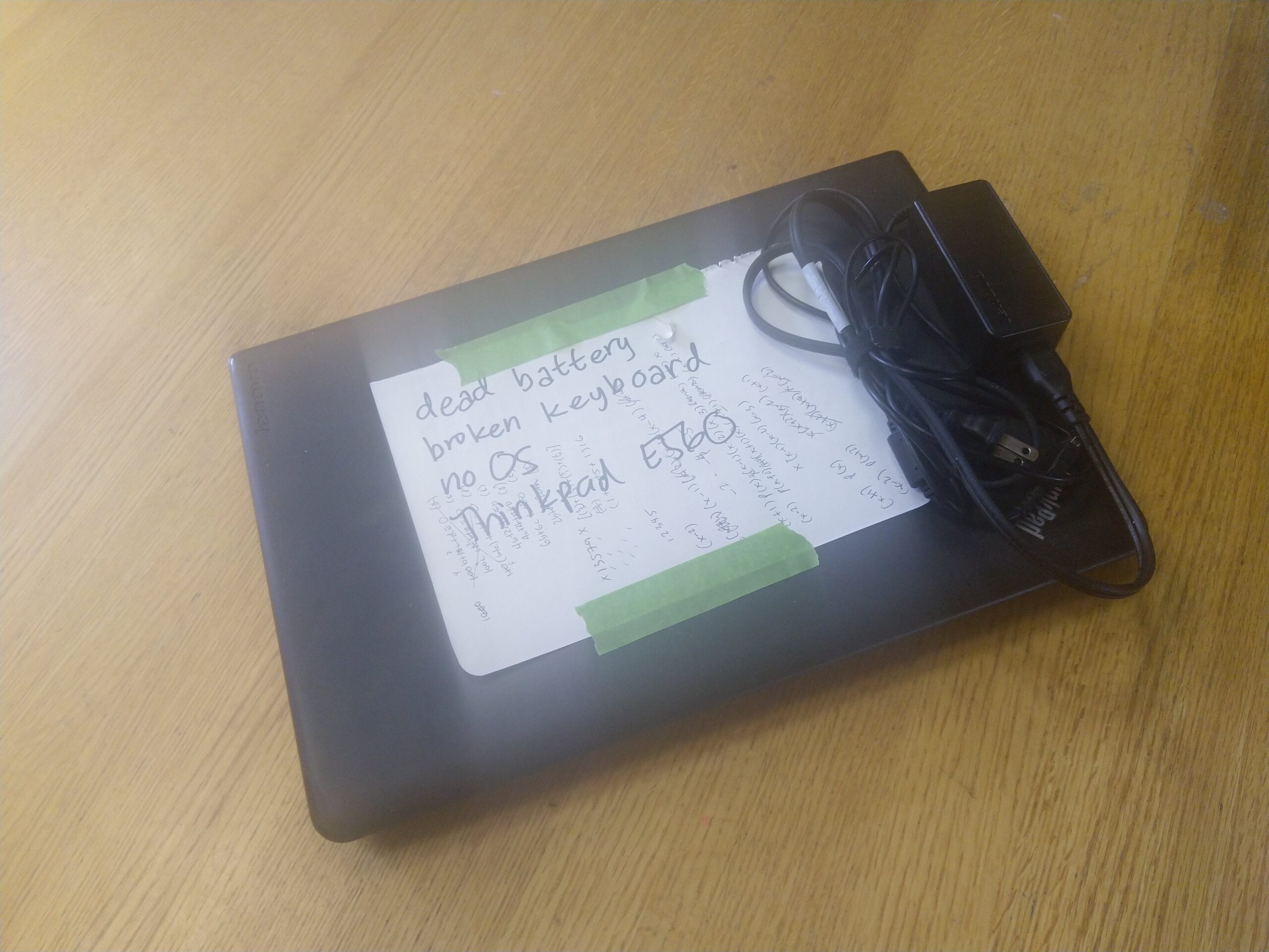 laptop with a note taped on it "dead battery, broken keyboard, no os, thinkpad e560"