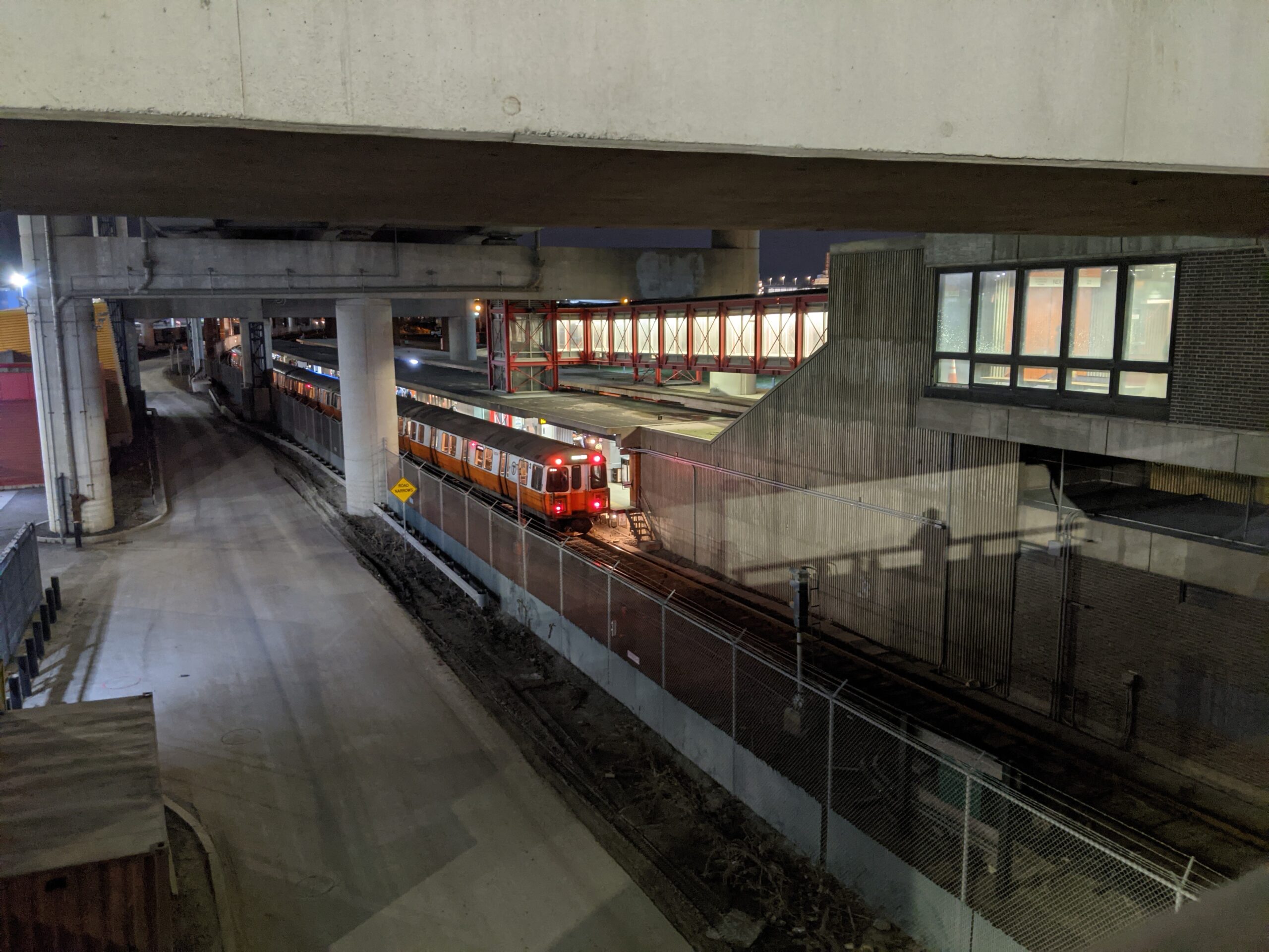 picture of orange line train stopped at a station at night