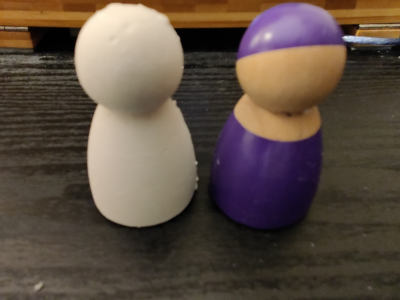 two figurines, one made of plaster and another made of wood