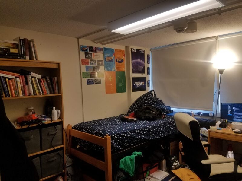 bed, shelves in messy dorm room