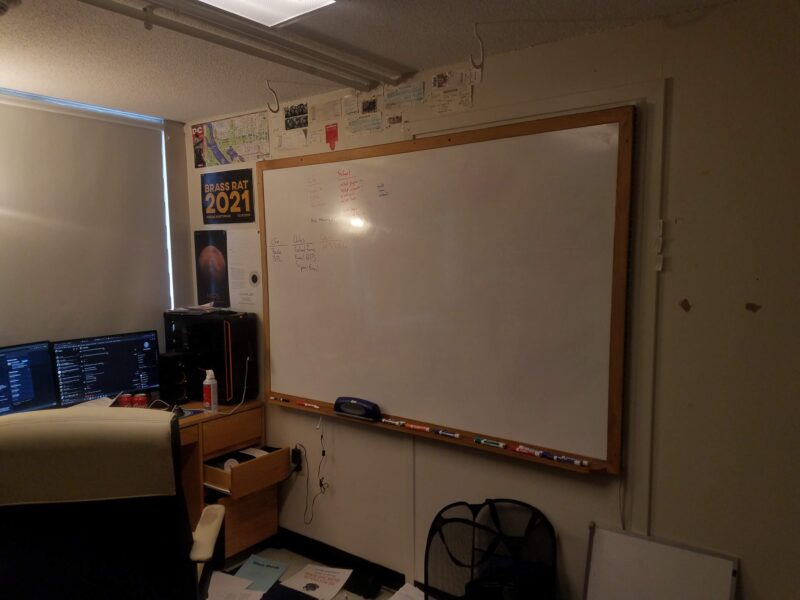 whiteboard, computer in messy dorm room