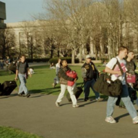 students walking across kresge lawn carrying bags