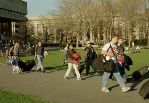 students walking across kresge lawn carrying bags