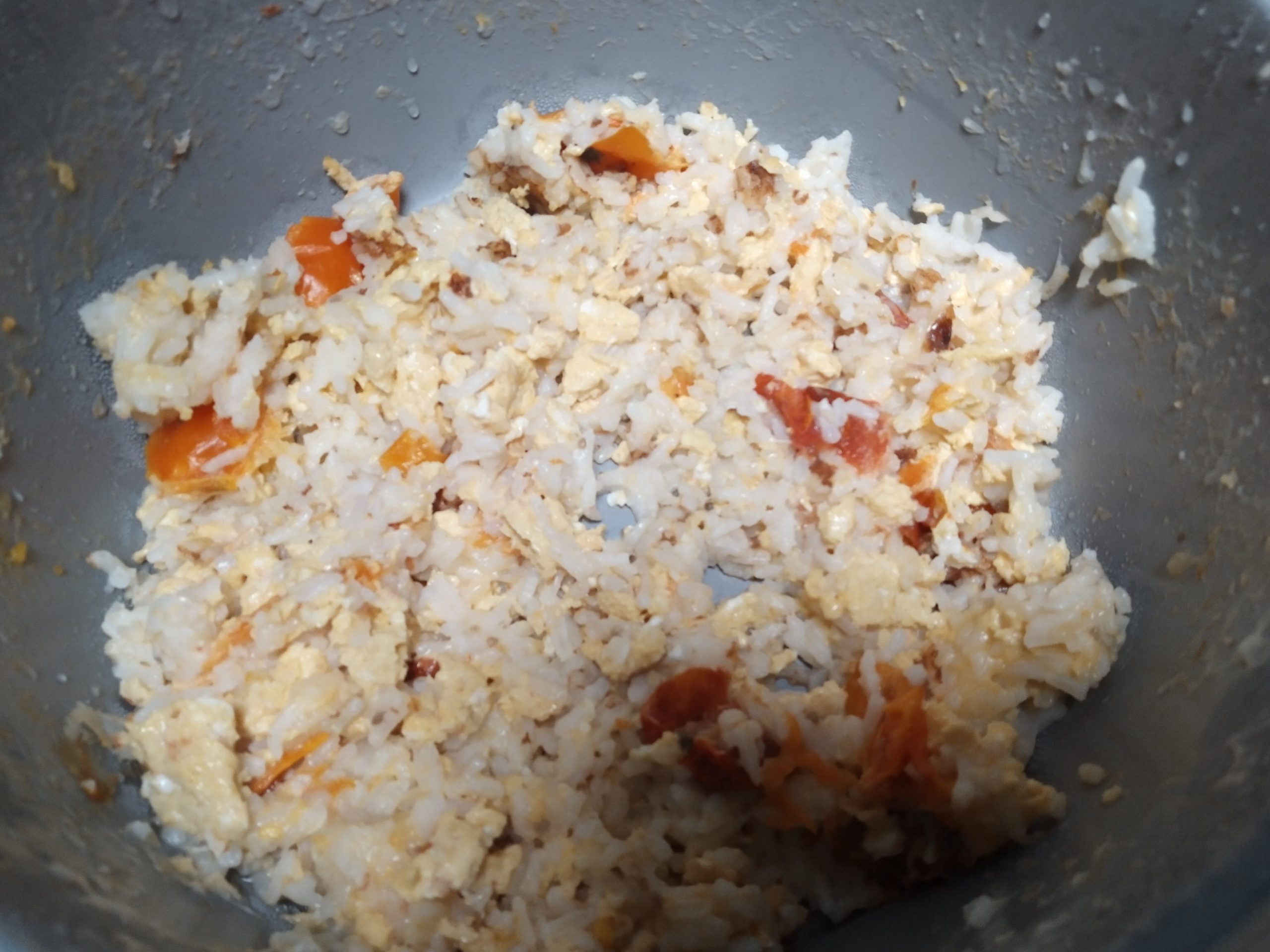 eggs and tomatoes and cheese and rice in a rice cooker