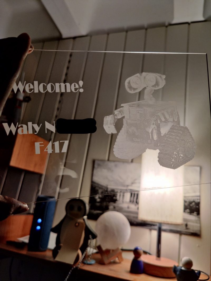 a clear laser cut acrylic with wall-e and welcome! on it