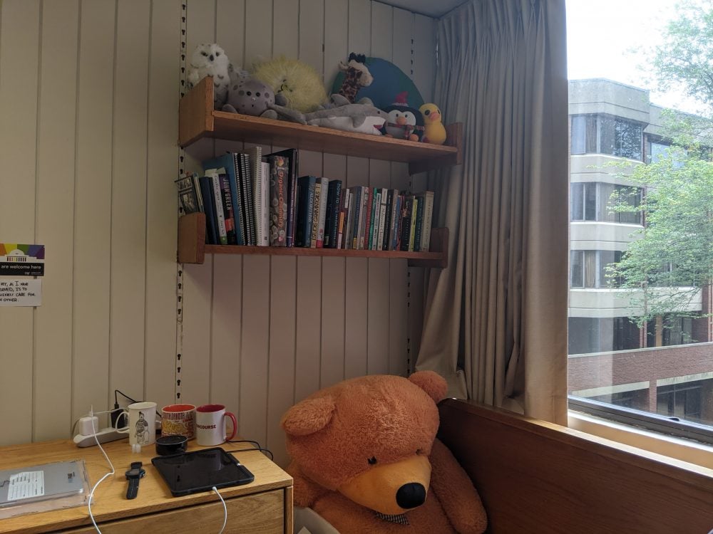 two shelves above a desk next to a window