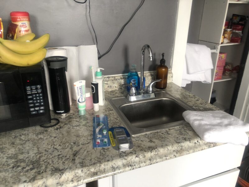 other half of countertop with sink, paper towels, etc.
