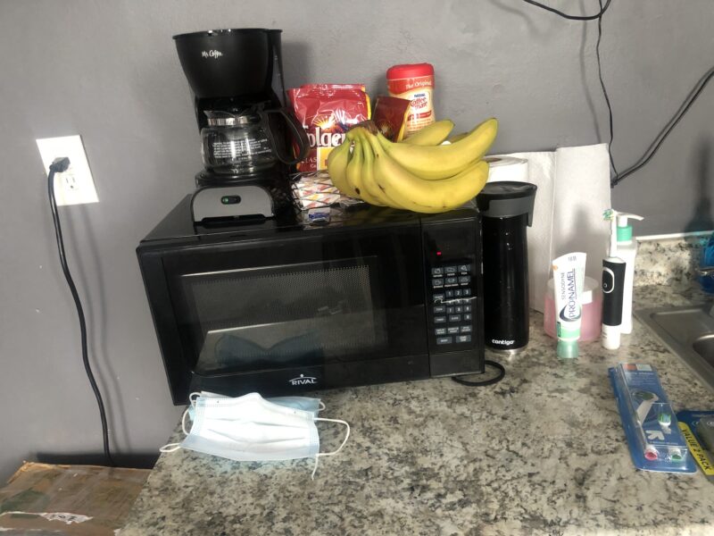 countertop with microwave, coffee maker, banana, and misc. kitchen things