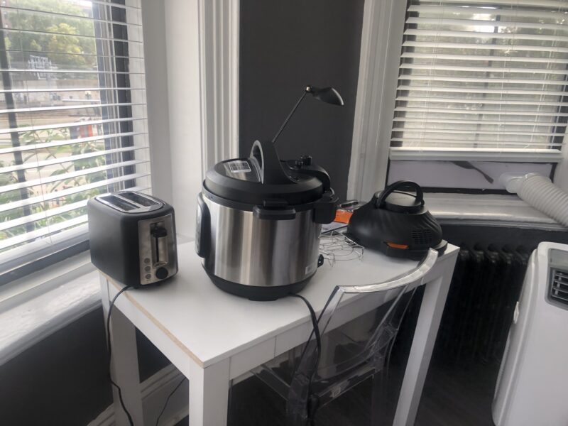 pressure cooker and toaster atop white table