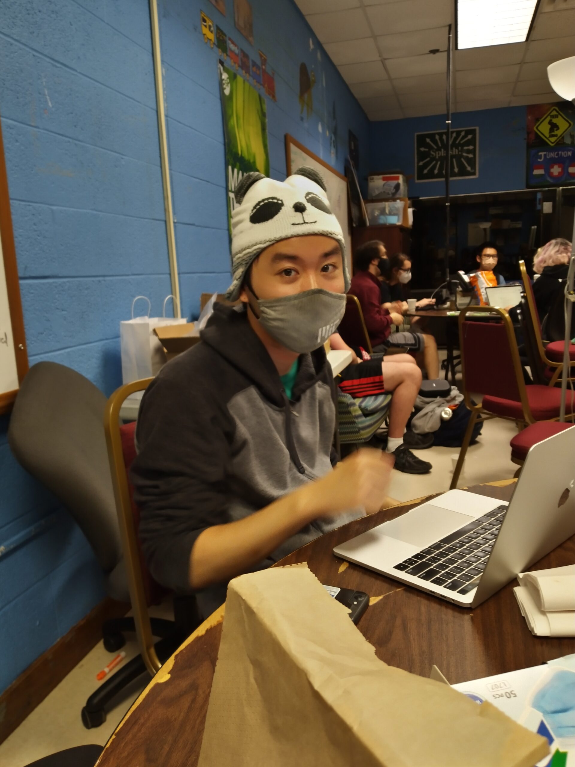 someone wearing a panda hat in front of a laptop