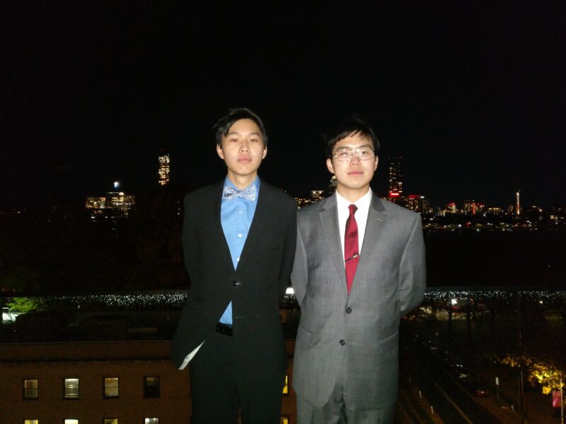 two people in formal wear against the boston skyline