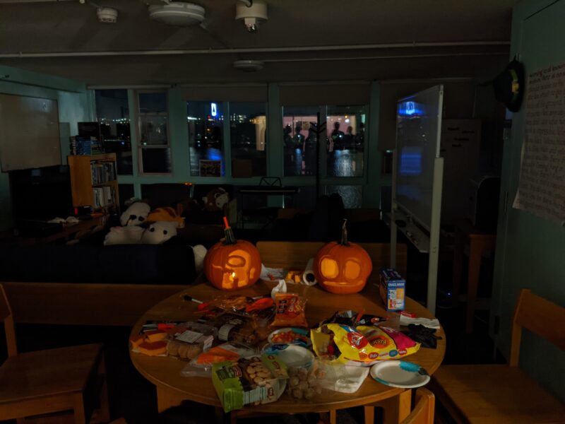 two carved pumpkins on a table in a dark lounge