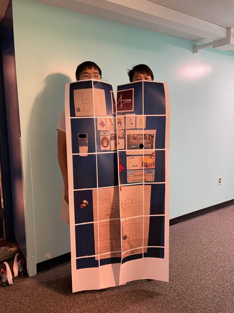 two people wearing twelve pieces of paper taped together which covers their body from below the eyes to the ground
