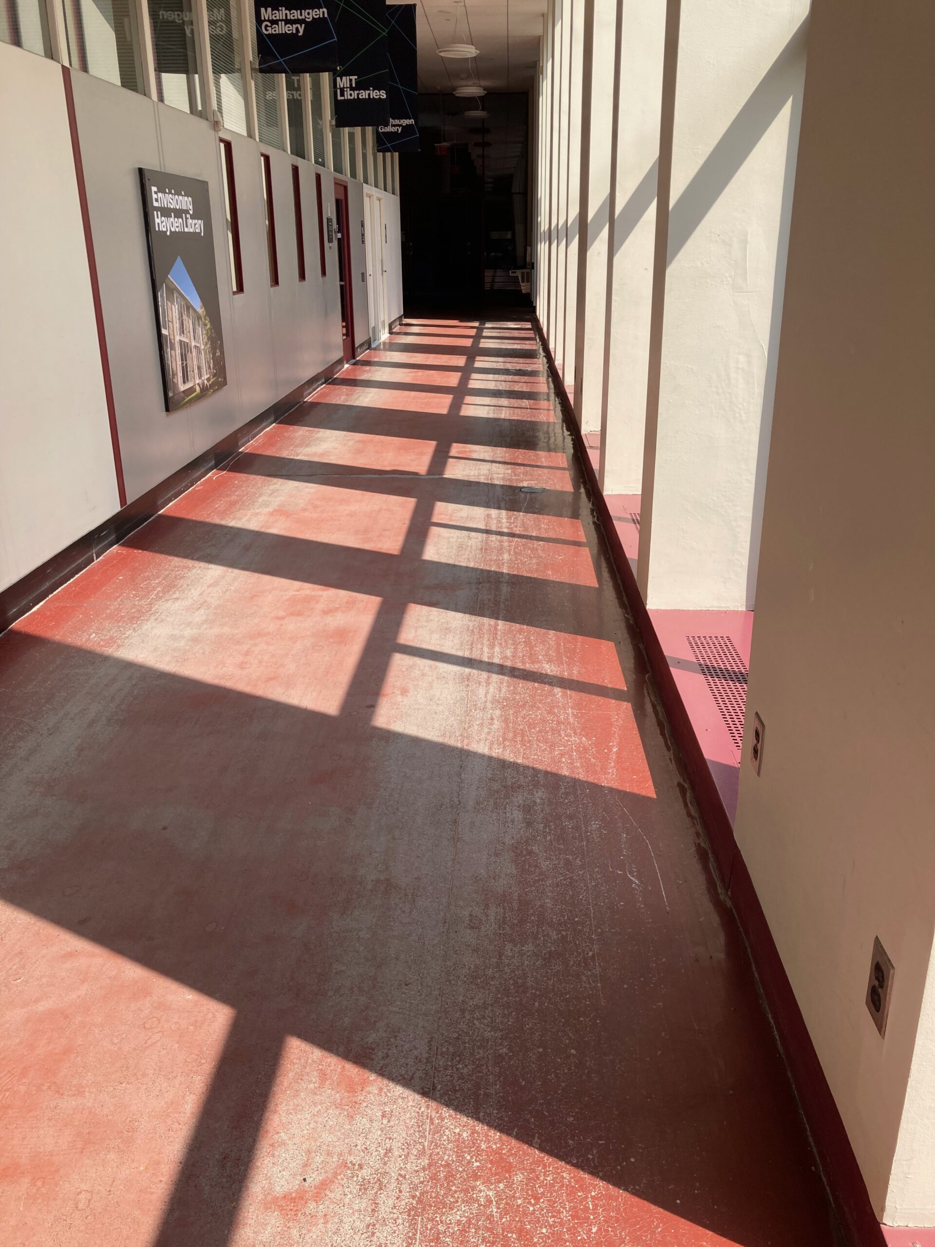 The floor of Hayden library hallway. Because of windows that are mostly not visible, light falls in square patterns on the floor.