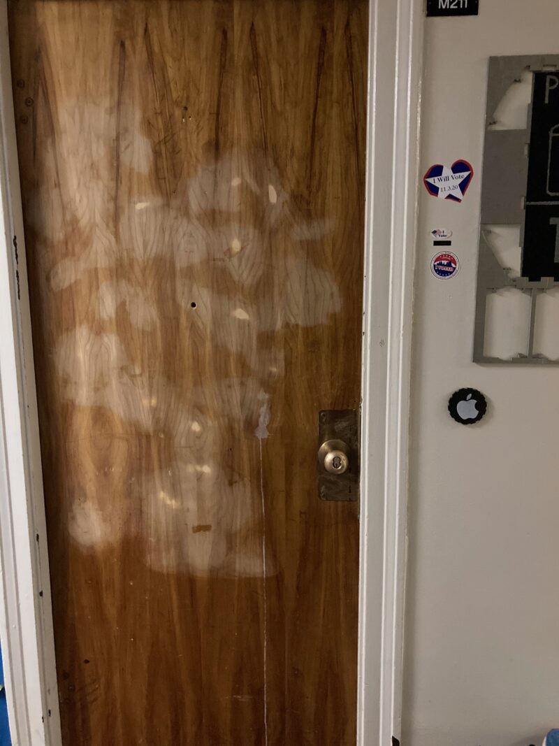 My door ebfore being painted or cleaned. It is unpainted wood with lots of stains and tape marks.