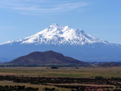 snow-capped peak overlooking a grassy field