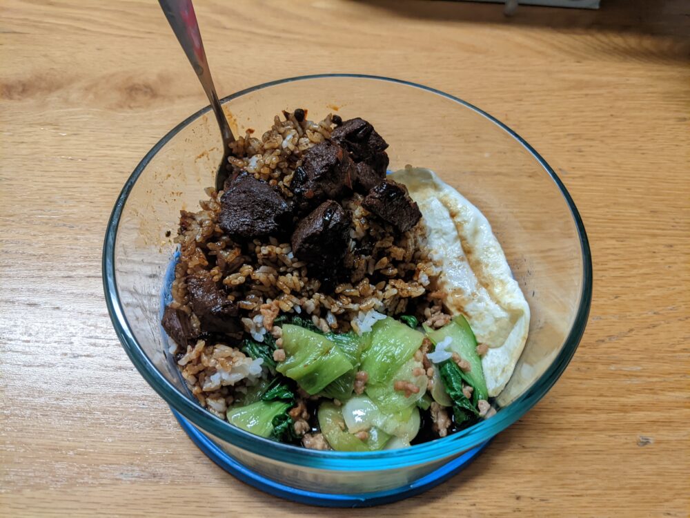 meat on rice, with vegetables and a fried egg