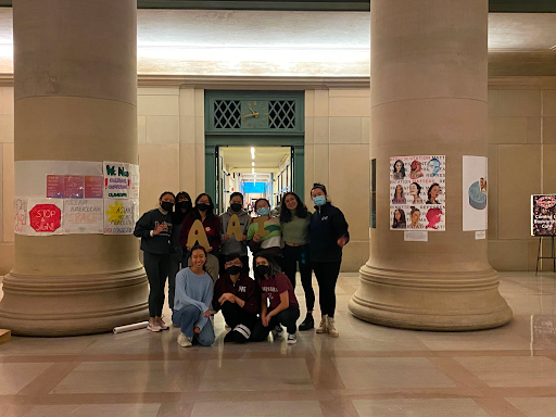 group of students standing in front of posters in mit building