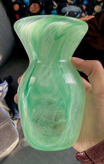 A glass vase with green-and-white swirls.