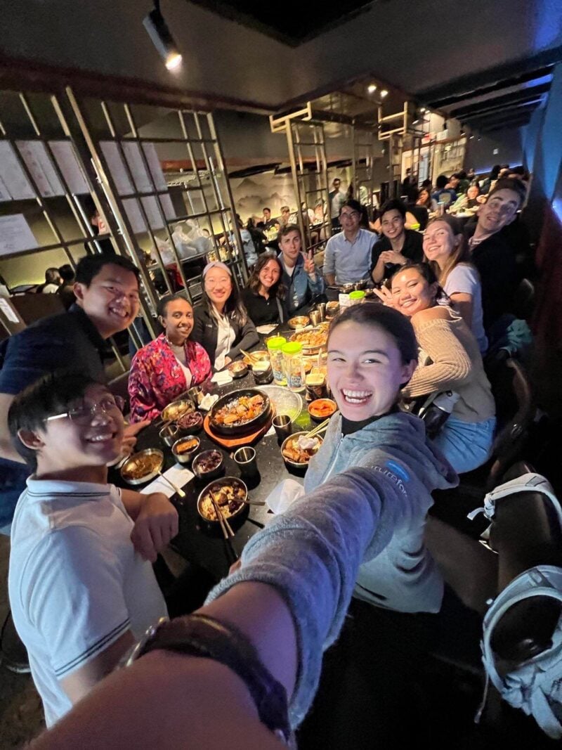 Group of students around a table full of food.
