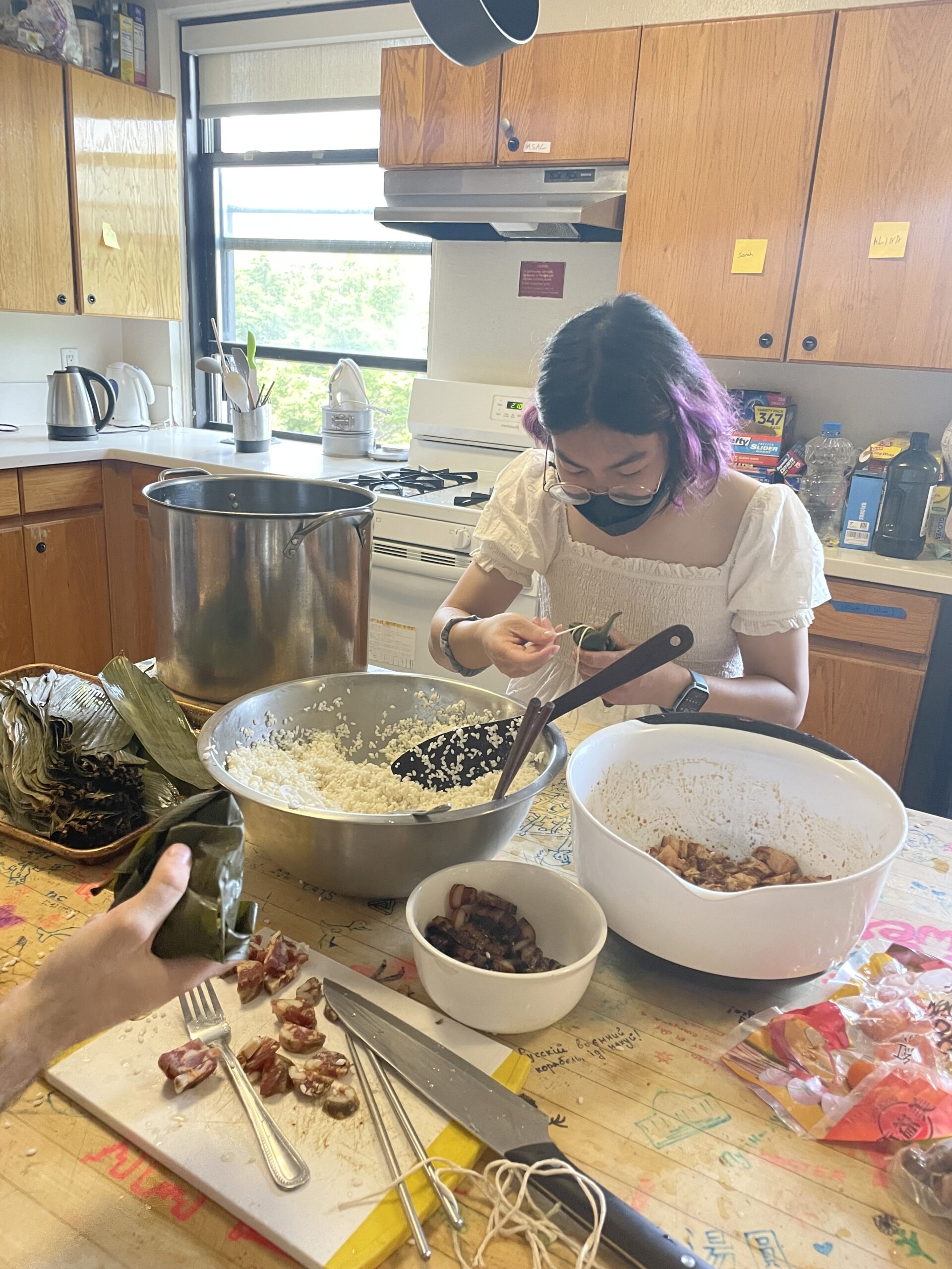 Winnie, staring intently at a zongzi while wrapping it