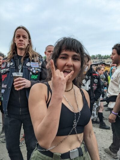 me doing the devil horn symbol w my tongue out while a random dude in the crowd observes disapprovingly