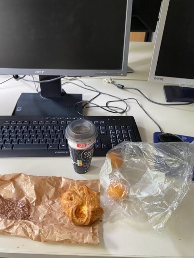 pastry, coffee, and apricots at a computer desk