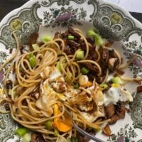 plate with spaghetti, mushrooms, and greens